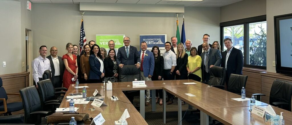 Washington Governor Jay Inslee and Washington state legislators are surrounded by VERTical Industry Roundtable presenters and attendees.